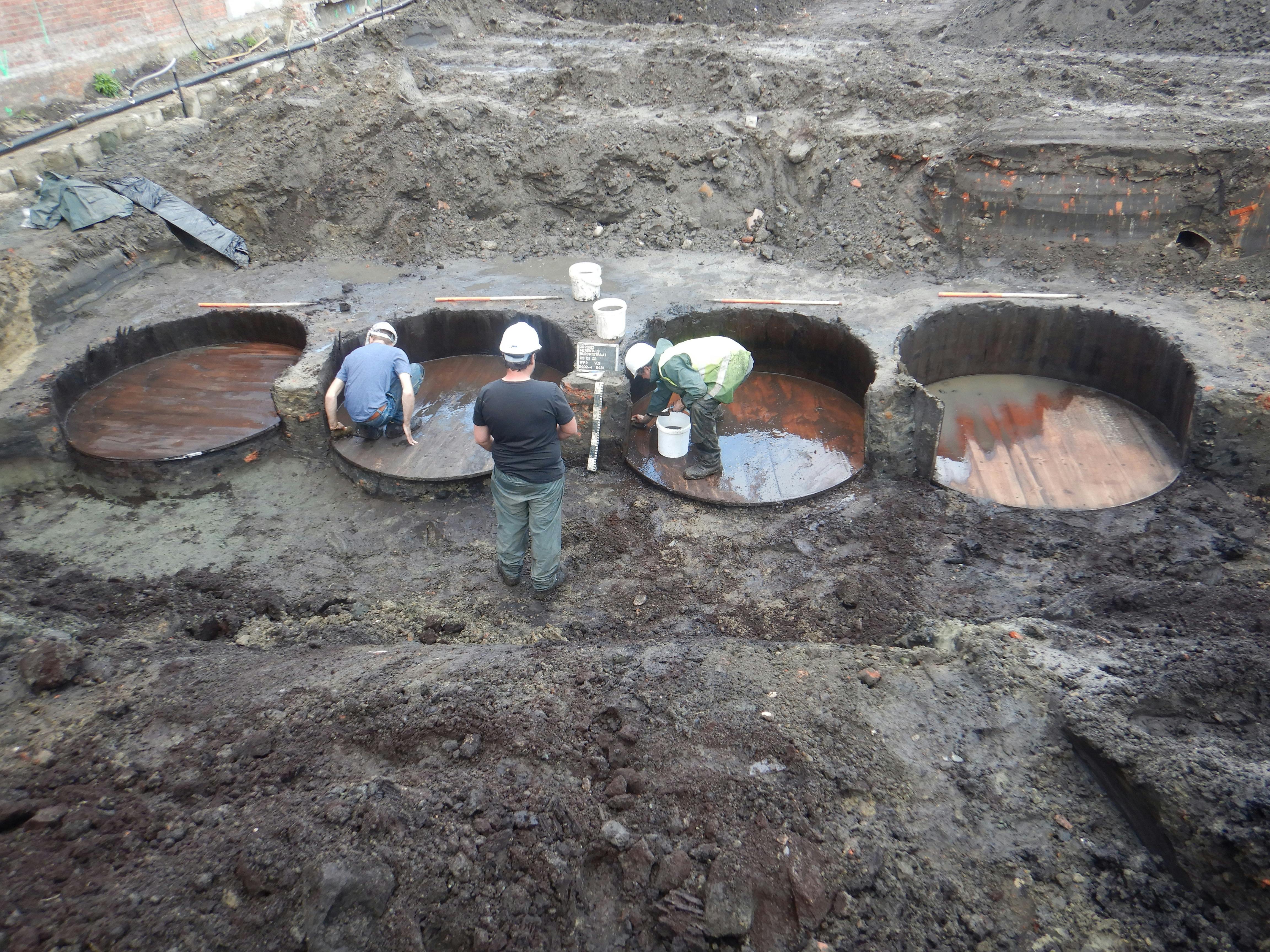 Archeoloog aan het werk - reinigen leerlooierskuipen op opgraving in Herentals
